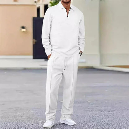 Hombre vistiendo conjunto deportivo blanco de manga larga y pantalón holgado, estilo casual urbano.