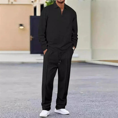Hombre vistiendo conjunto casual negro de manga larga y pantalón, con tenis blancos, al aire libre