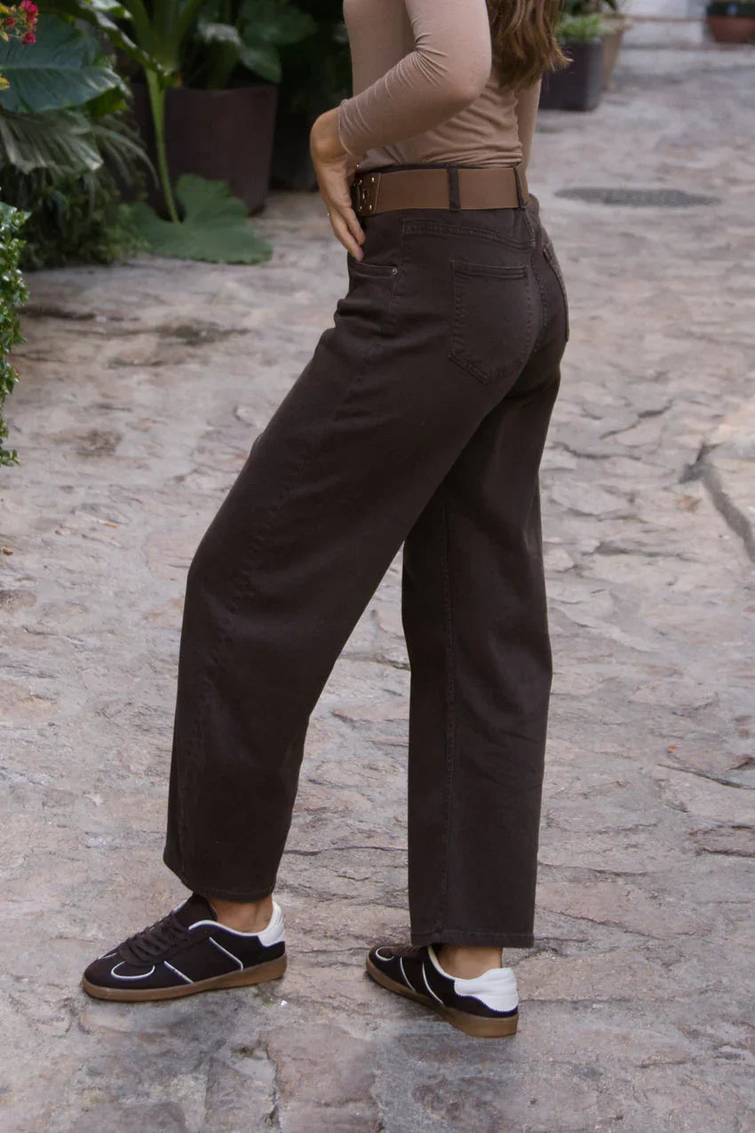 Pantalón de mezclilla café para mujer estilo casual, corte recto, en calle empedrada.