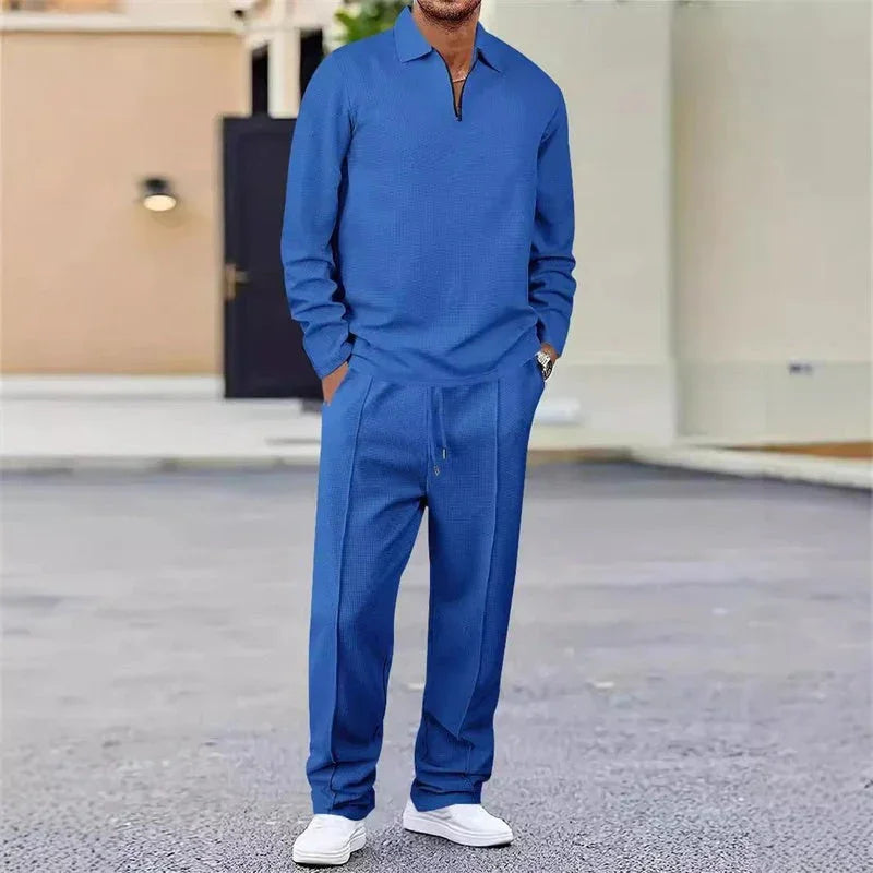Hombre con conjunto casual azul de pantalón y suéter, zapatos blancos, estilo moderno callejero