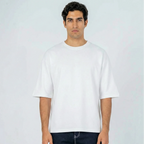 Hombre con camiseta oversize blanca de manga corta y cuello redondo, fondo claro