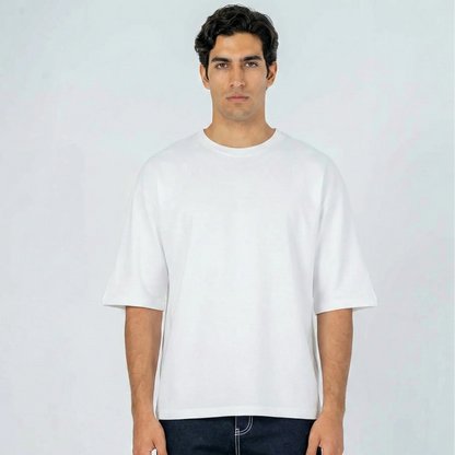 Hombre con camiseta oversize blanca de manga corta y cuello redondo, fondo claro