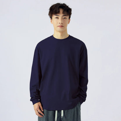 Hombre con camiseta de manga larga azul marino, fondo blanco, ropa casual masculina.