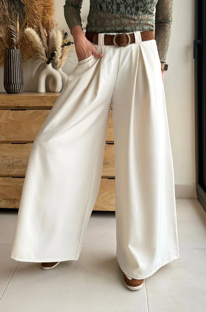 Pantalón palazzo blanco de tiro alto y cinturón marrón en ambiente moderno