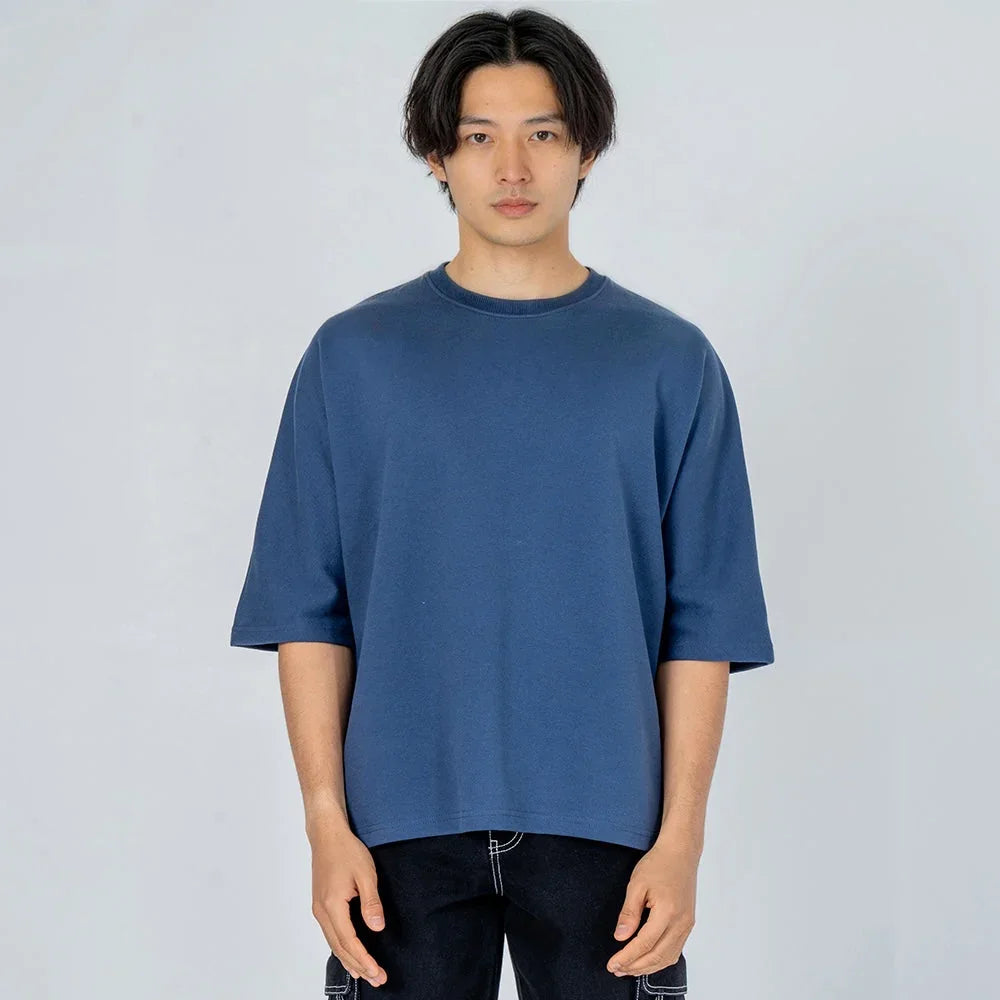 Hombre con camiseta azul de manga corta y cuello redondo, ropa casual minimalista.
