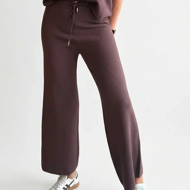 Conjunto de mujer marrón de punto con pantalón ancho, camiseta manga corta y zapatillas blancas.