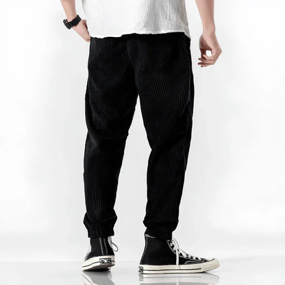 Pantalón jogger de pana negra para hombre, corte relajado, estilo casual, vista trasera