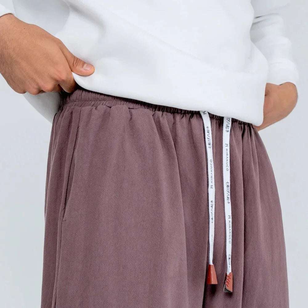 Pantalón gris suelto de cintura elástica con cordón ajustable y bolsillos, ropa casual