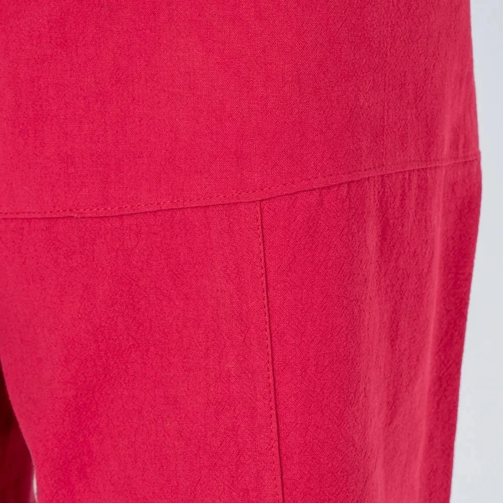 Detalle de pantalón rojo, tela de textura suave y costuras visibles